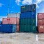A stack of various shipping containers in different colors under a blue sky at Southampton.